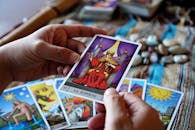 Hands holding tarot cards with 'La Justicia' card in focus during reading.